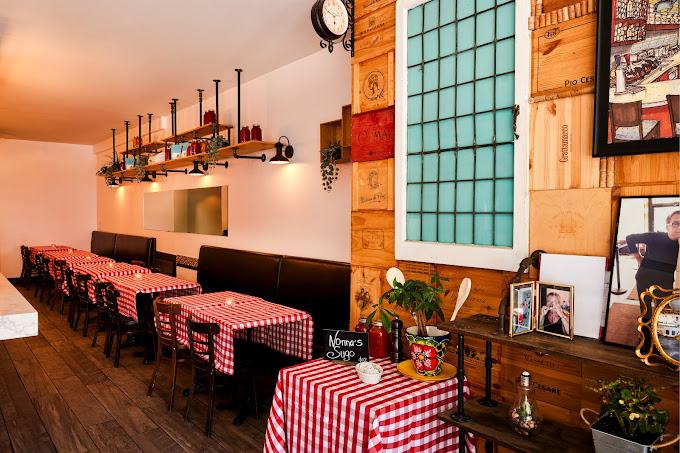 Cozy dining space for events at Mangiare, a family-friendly Italian restaurant in the Junction, Toronto, featuring rustic wooden tables and checkered tablecloths.